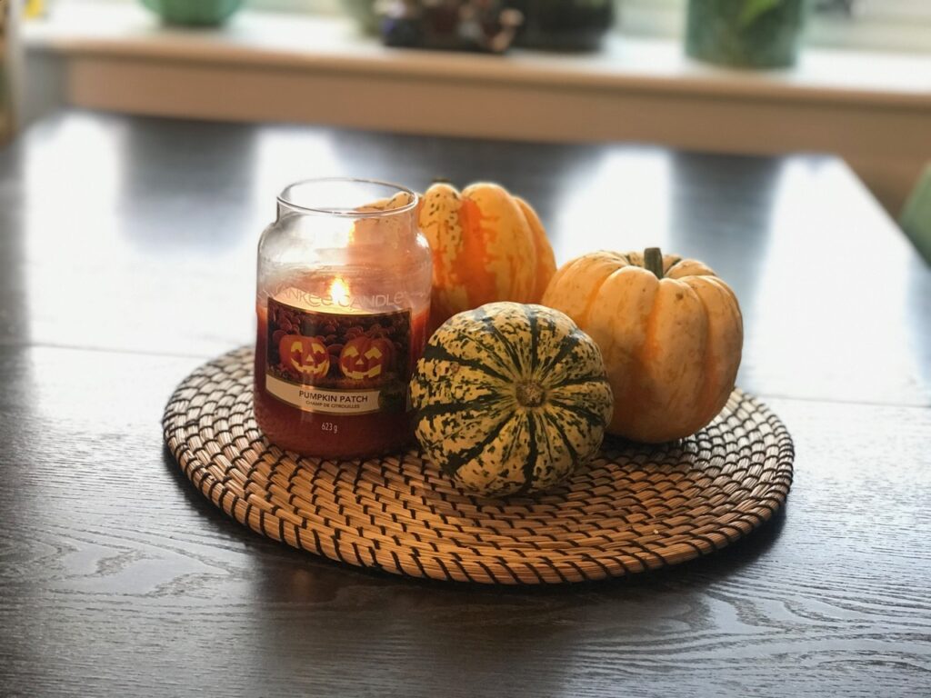 Yankee Candle burning next to pumpkins